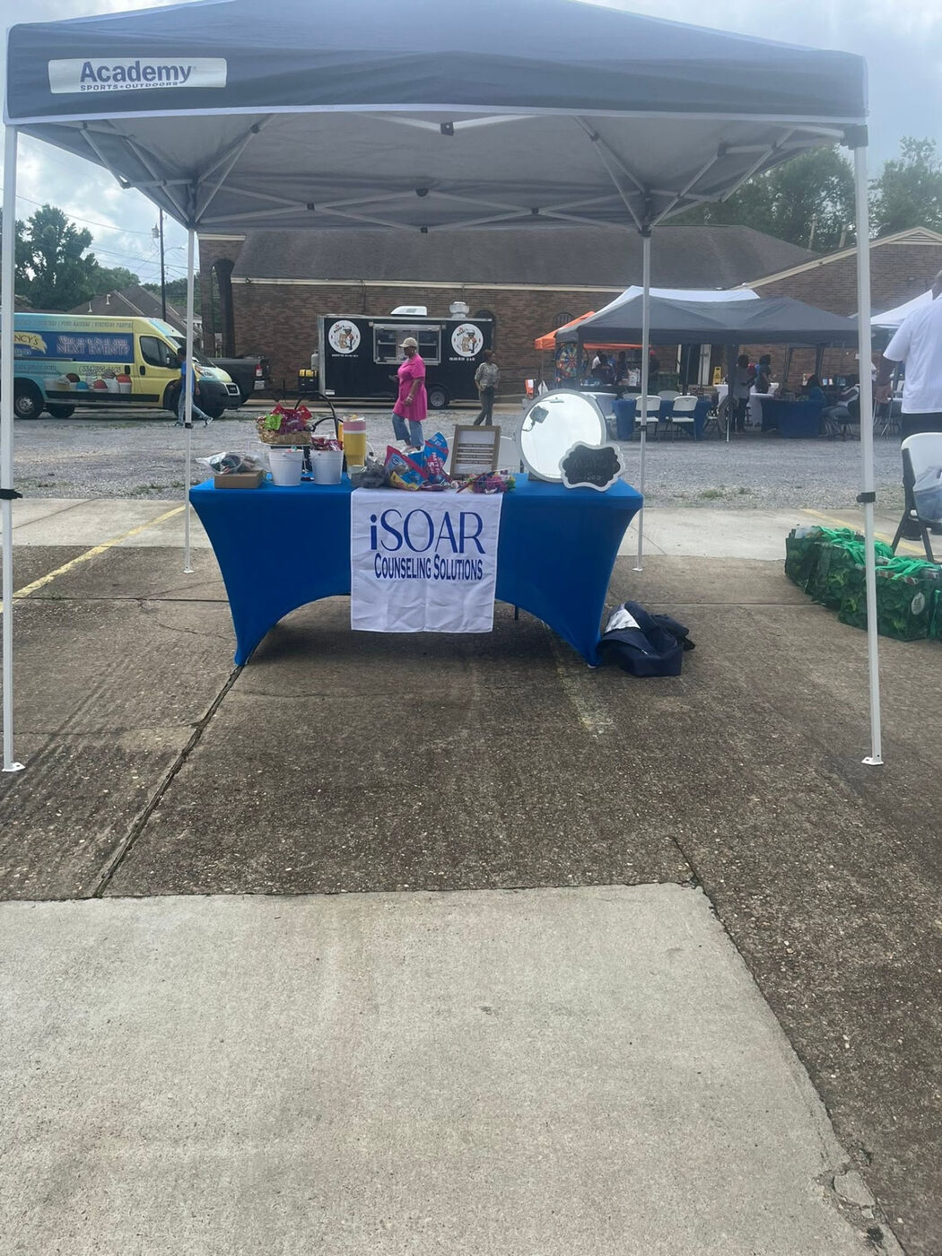 Academy Sports + Outdoors and iSOAR Counseling Solutions resource booths under a blue tent