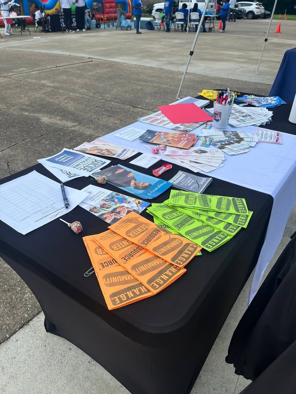 C.H.A.N.G.E. Community Resource Center brochures, suicide prevention lifeline literature and sign-in sheets on a black-clothed table