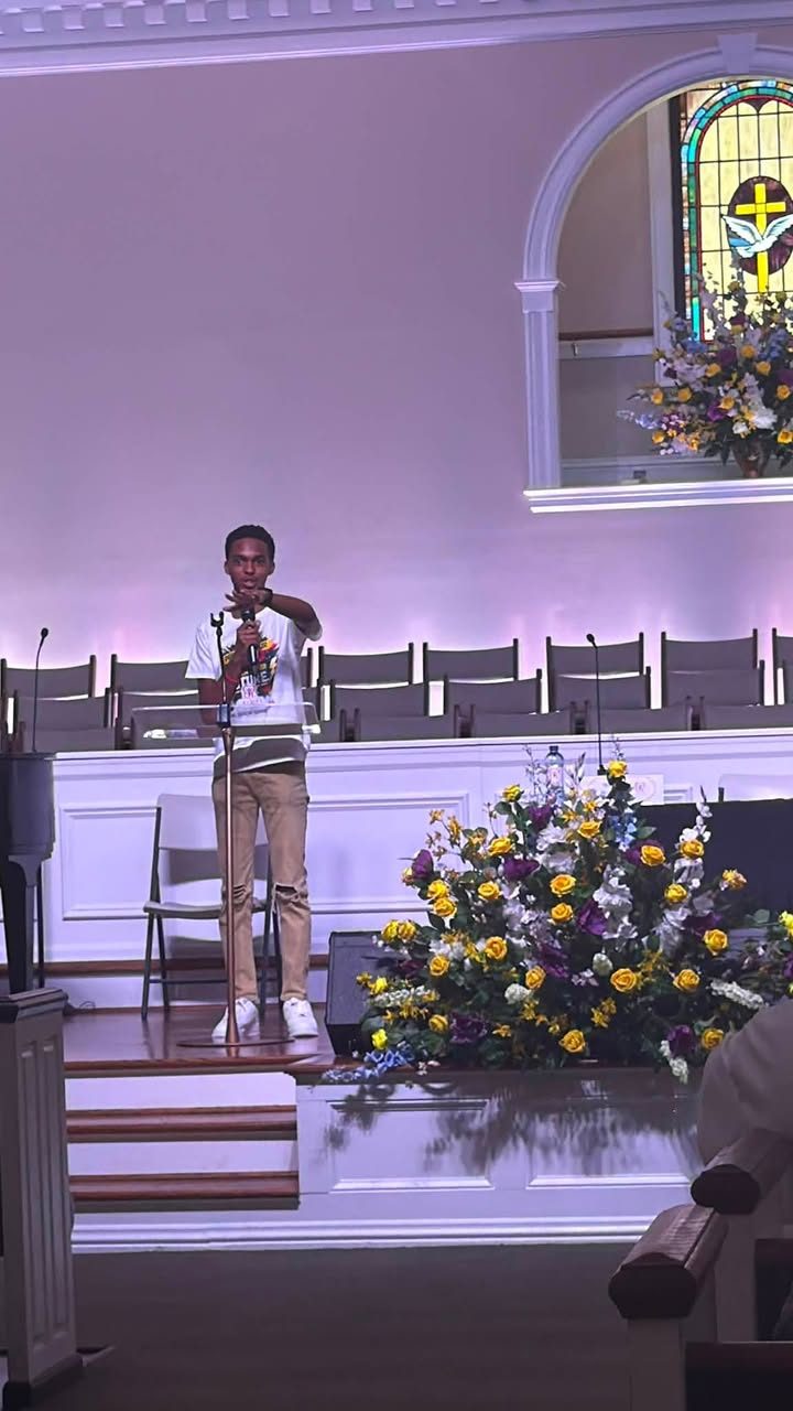 A speaker addressing summit attendees from the stage lectern
