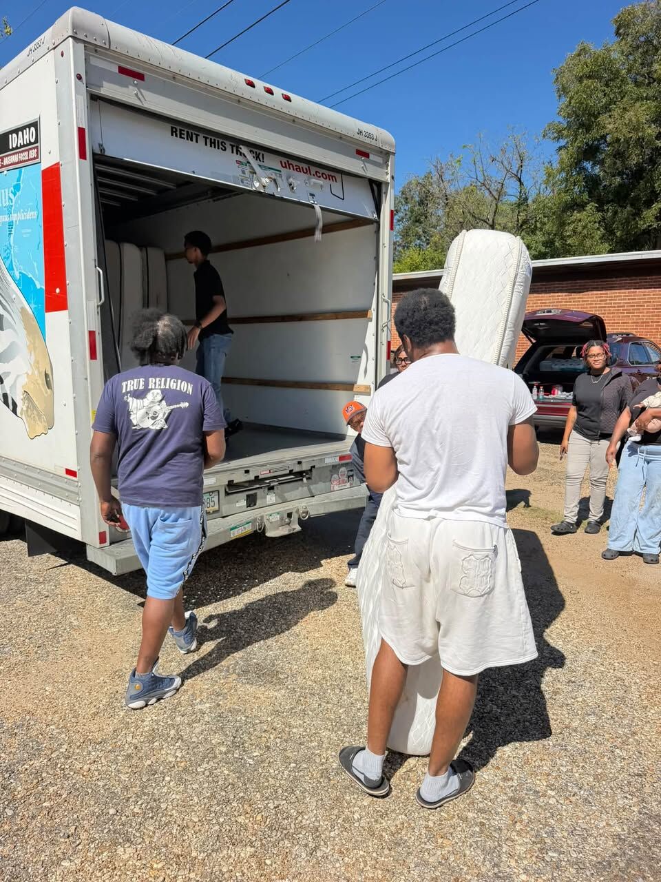 Volunteers unloading a mattress from the truck
