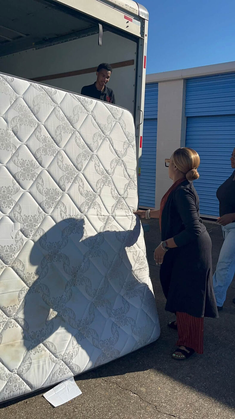 Volunteer standing a mattress upright for pickup