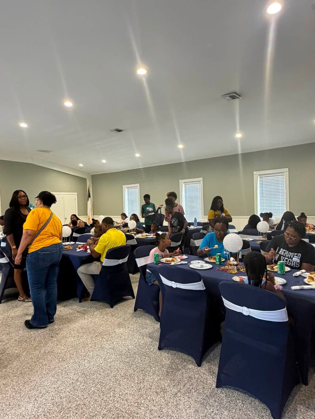 Attendees dining and talking at the summit reception in the fellowship hall