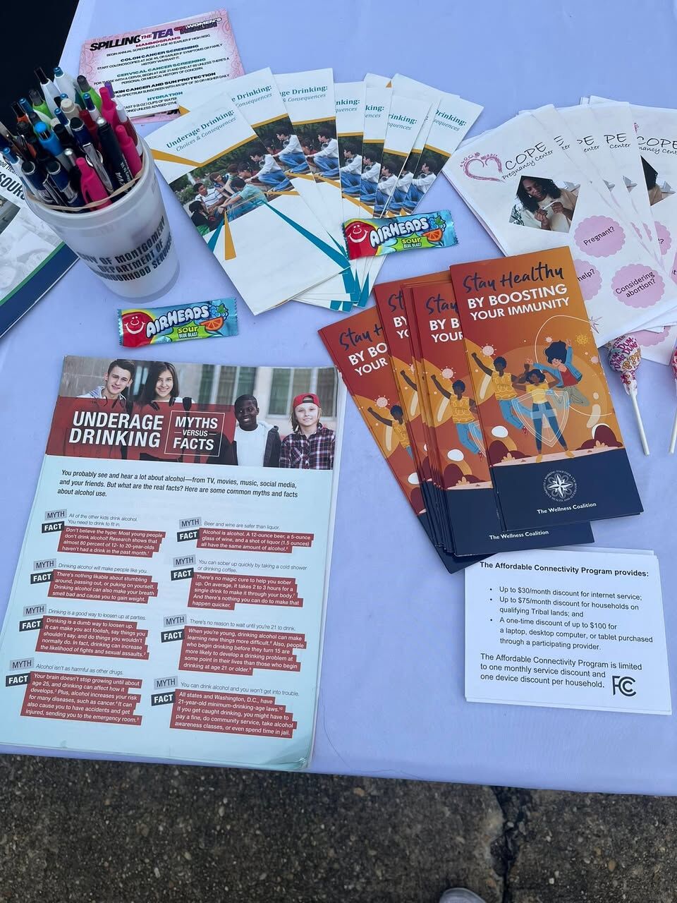 Overhead view of a community resource table laid out with brochures, handouts and candy