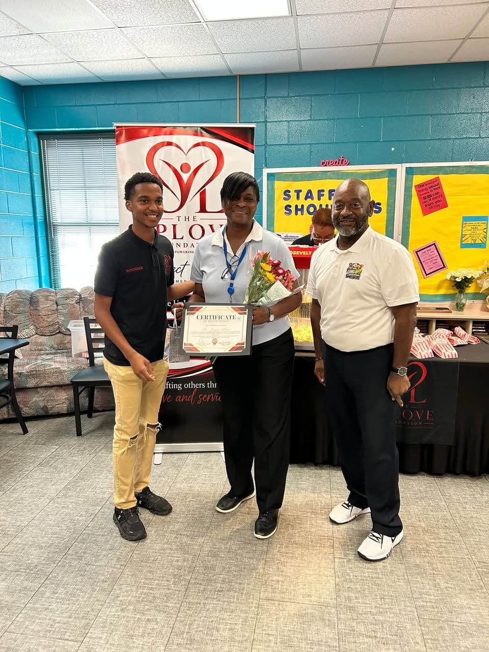Isaiah presenting a certificate of recognition to a Fitzpatrick Elementary staff member